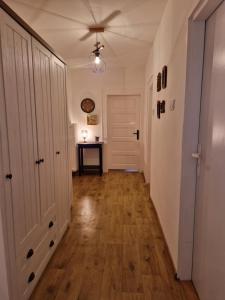 a hallway with a ceiling fan and a hallway with a hard wood floor at Orlik in Spišské Bystré