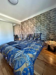 a bedroom with a large bed with a blue comforter at le gîte des frangines in Bitche