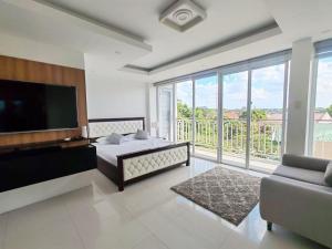 a bedroom with a bed and a flat screen tv at 7BR Luxury Resort with Pool and Bar in Sampong