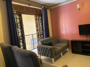 a living room with a couch and a chair and a television at DAVE's LIVING in Kampala