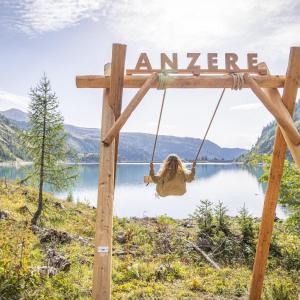 een vrouw op een schommel voor een meer bij Loft lumineux et confortable in Grimisuat +14 foto's