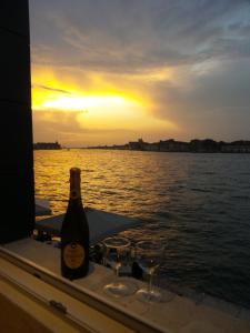 - une bouteille de vin sur une table avec des verres sur un bateau dans l'établissement 3 Windows on St Mark - Waterfront Apartment, à Venise 31 autres photos