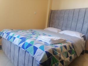a bed with a quilt on it in a room at Lee's Home in Thika