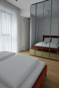 un dormitorio con una cama y un espejo en Efinity Sea View Luxury Apartment, en Mamaia