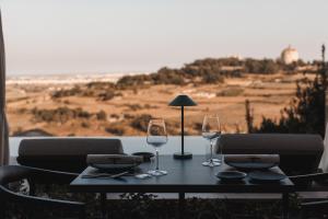 a table with two wine glasses on top of it at Verdala Wellness Hotel AX Privilege - Adults Only in Rabat
