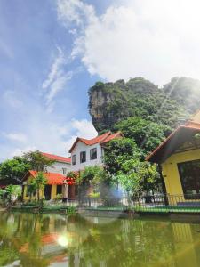 a group of houses next to a body of water at Trang An Hana homestay in Nguyên Ngoại