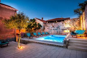 una piscina con sillas azules y un edificio en California Apartments, en Dubrovnik