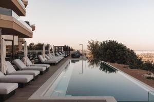 a swimming pool with chaise lounge chairs next to a building at Verdala Wellness Hotel AX Privilege - Adults Only in Rabat