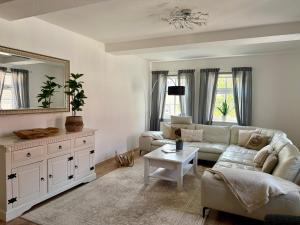 a living room with a couch and a mirror at Ferienwohungen und Apartments Haus zum Schwan in Arnstadt