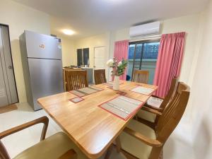 a kitchen with a wooden table and a refrigerator at Kata beach Townhouse BL2 in Kata Beach