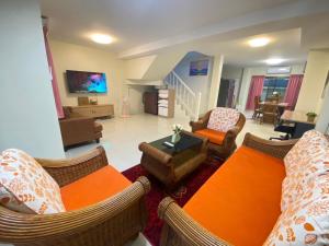 a living room with a couch and chairs and a tv at Kata beach Townhouse BL2 in Kata Beach