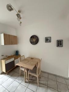 a kitchen with a table and chairs in a room at T1 bis proche Techn'hom in Belfort