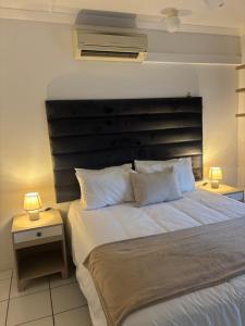 a bedroom with a large white bed with two lamps at The Sandalwood Self-Catering Accommodation in Durban