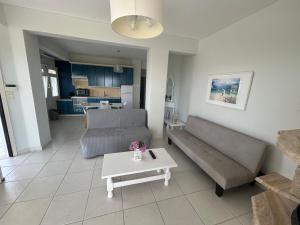 a living room with a couch and a table at OLIVE&VIEW in Nea Moudania