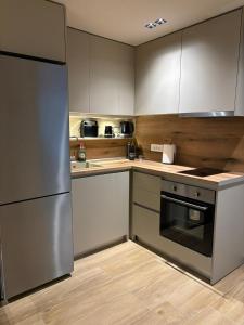 a kitchen with white cabinets and a stainless steel refrigerator at ΝΕΑΚΙΤΟΣ Luxury Apartments in Nikiti