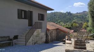 a house with a staircase next to a building at Casa Ermida in Pincães