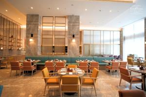 a dining room with tables and chairs and windows at Siddharth The Fern An Ecotel Hotel,Jalna in Jālna