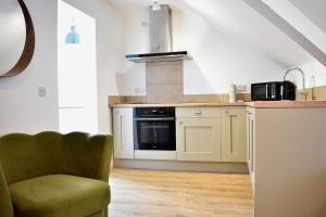 a kitchen with a green chair in a room at Stylish Modern Flat in Doncaster Centre in Doncaster