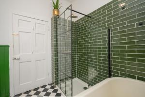 a bathroom with green subway tiles and a tub at Banrigh House in Stirling +25 photos
