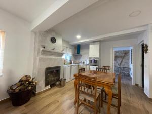 a kitchen and dining room with a table and a fireplace at La CASA de mis PADRES 2 in Arahuetes