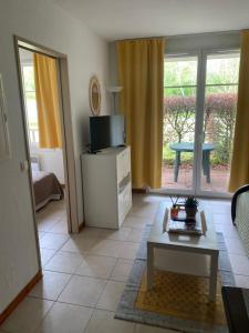 a living room with a tv and a table at Chez Adelaïde in Levernois