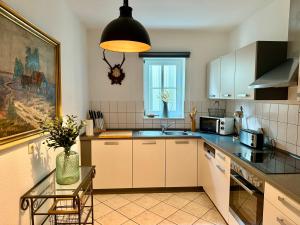 a kitchen with white cabinets and a vase of flowers at Ferienwohungen und Apartments Haus zum Schwan in Arnstadt