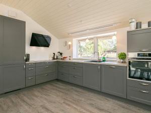 a large kitchen with gray cabinets and a window at 8 person holiday home in Væggerløse in Marielyst