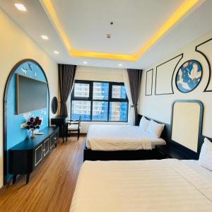 a hotel room with two beds and a flat screen tv at FLC Ocean View Quy Nhon in Quy Nhon +167 photos
