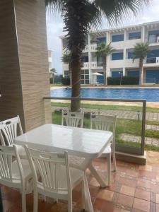 a white table and chairs with a view of a building at Appartement Mansouria in Sidi el Haj Bou Derbala