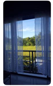 a window with white curtains and a view of a field at E&Z guest house in Sara