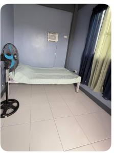 a small hospital room with a bed and a fan at E&Z guest house in Sara