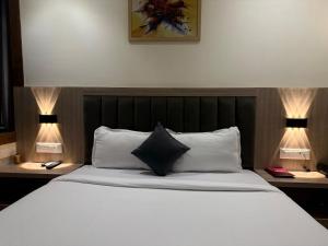 a bedroom with a bed with two lamps on both sides at Hotel Riza - Near Nesco Exhibition Centre in Mumbai