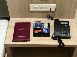 a desk with a telephone and a book on it at Hotel Riza - Near Nesco Exhibition Centre in Mumbai