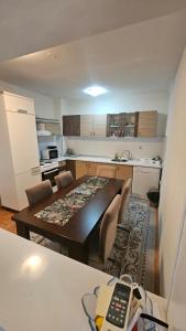 a kitchen with a table and a dining room at Doboj Apartman in Doboj