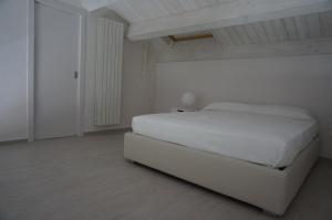 ヴァストにあるResidenza Diomedeaの白いベッドルーム(白いベッド1台、ドア付)