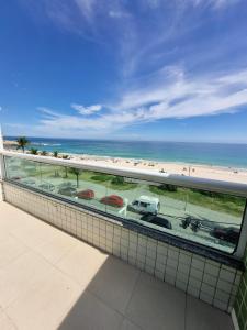 a balcony with a view of a beach and the ocean at Hotel Aconchego da Vila A in Saquarema