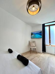 1 dormitorio con cama, lámpara y silla en Superbe T3 à 15 min de Lyon, en Pierre-Bénite