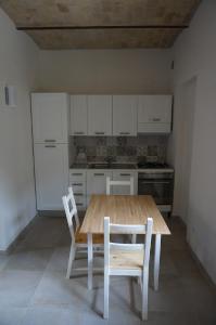 ヴァストにあるResidenza Diomedeaのキッチン(木製テーブル、椅子2脚付)