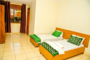 a room with two beds with green and white pillows at Macchiato Suites Boutique Hotel in Kigali