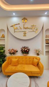 a living room with a couch and a clock on the wall at Tom's Homestay 2 in Hue