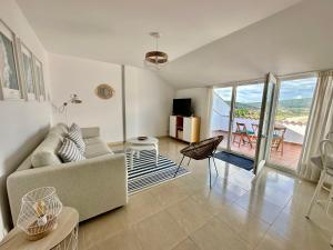 フィステーラにあるCasa del Faro Finisterre - Itsasargia etxeaのリビングルーム(ソファ付)、バルコニーが備わります。
