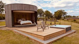 a circular house with a bed and a chair on a deck at Domaine de Chabrague in Amou