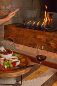 a table with a plate of food and a glass of wine at Coração da Terra Praia do Rosa in Praia do Rosa