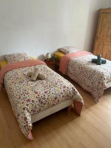 a bedroom with two beds with flowers on them at Le reflet de la cathédrale in Saint-Omer