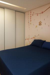 a bedroom with a blue bed and a wall at Village Prime Umarizal in Belém +5 photos
