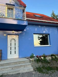 a blue house with a white door and a window at Blue cottage near Krakow in Rudawa