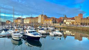 a bunch of boats are docked in a harbor at Yate en Gijon , experiencia única in Gijón
