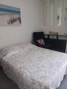 a bedroom with a bed and a chair and a picture at Studio avec jardinet et balcon idéalement situé in Balaruc-les-Bains
