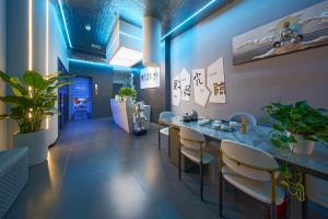 a restaurant with a table and chairs and plants at ZhangJiaJieWuLingYuan栖见云舍Hotel in Hanqiyu