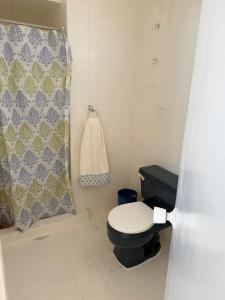 a bathroom with a toilet and a shower curtain at Apartamento vista al mar Seaview apartment in Pampatar